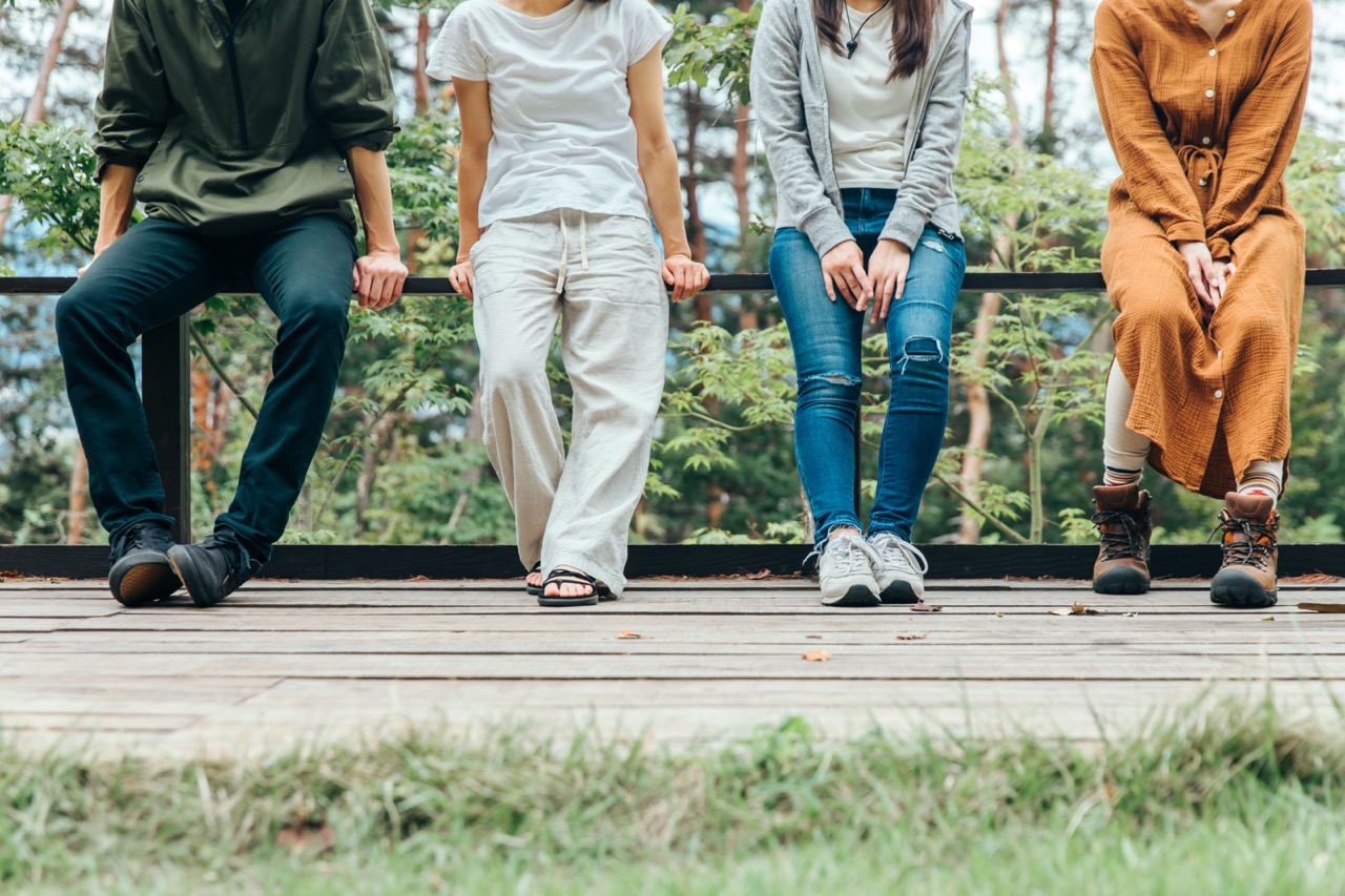 A happy group of friends hiking in the autumn forest, enjoying a sunny day and having fun conversations.