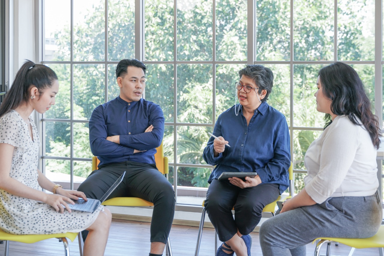 A happy group of friends hiking in the autumn forest, enjoying a sunny day and having fun conversations.